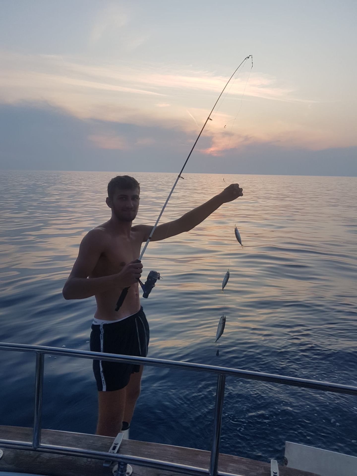 Angler with multiple fish on the line at dusk
