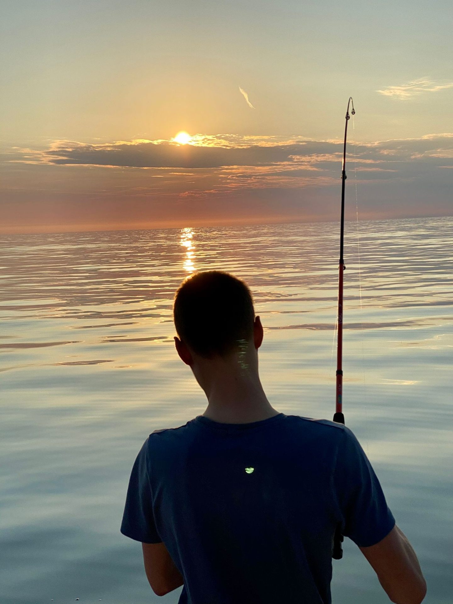 Silhouette angler watching Adriatic sunrise