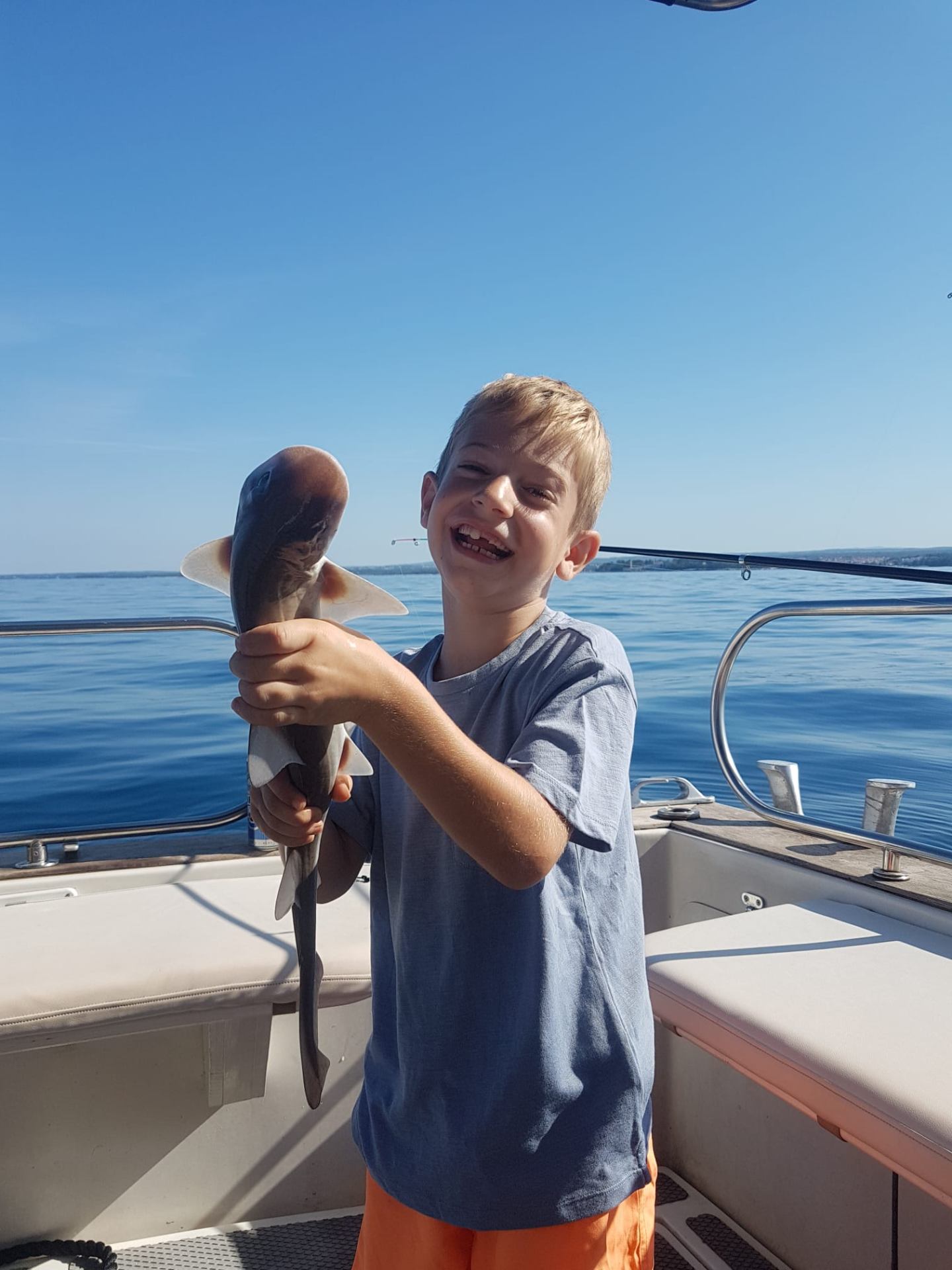Laughing kid with a small shark catch