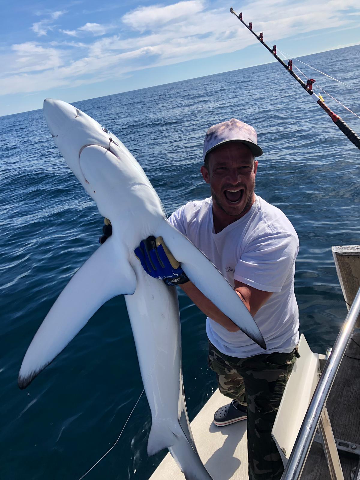 Guest with a blue shark catch offshore